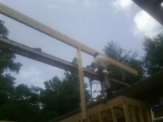 Carpenter setting a ridge beam over a new addition frame — Ice Dam Removal by Roofing Brothers in Bloomingburg