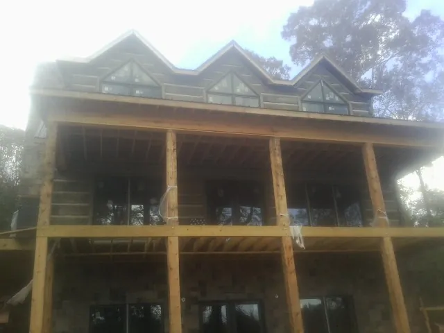 Dormers and porch framing on a large log home under construction — Roof Coating work by our crew in Bloomingburg