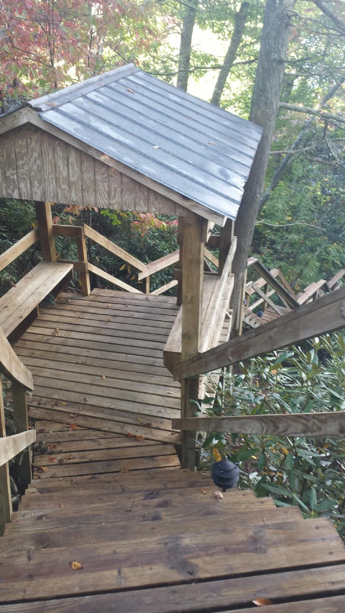 Metal roofed shelter over wooden steps on a wooded walkway — Skylight Repair & Installation work by our crew in Bloomingburg