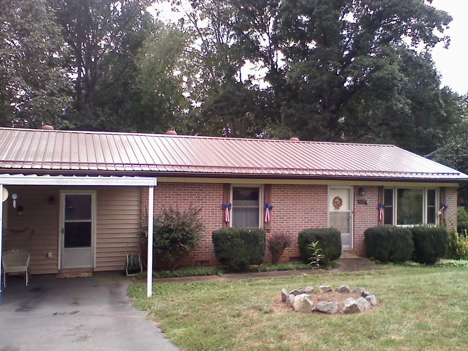 Bronze metal roof and carport on a brick ranch home — Roof Repair work by our crew in Bloomingburg